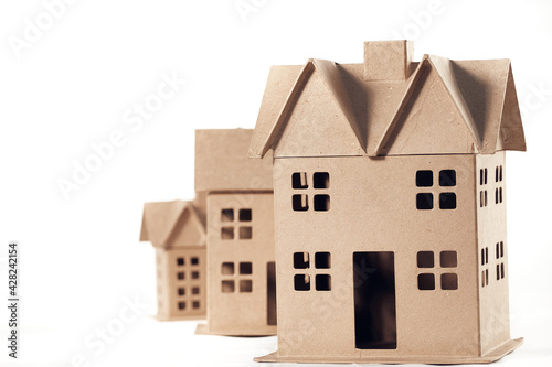 Three houses made of cardboard isolated on white background.