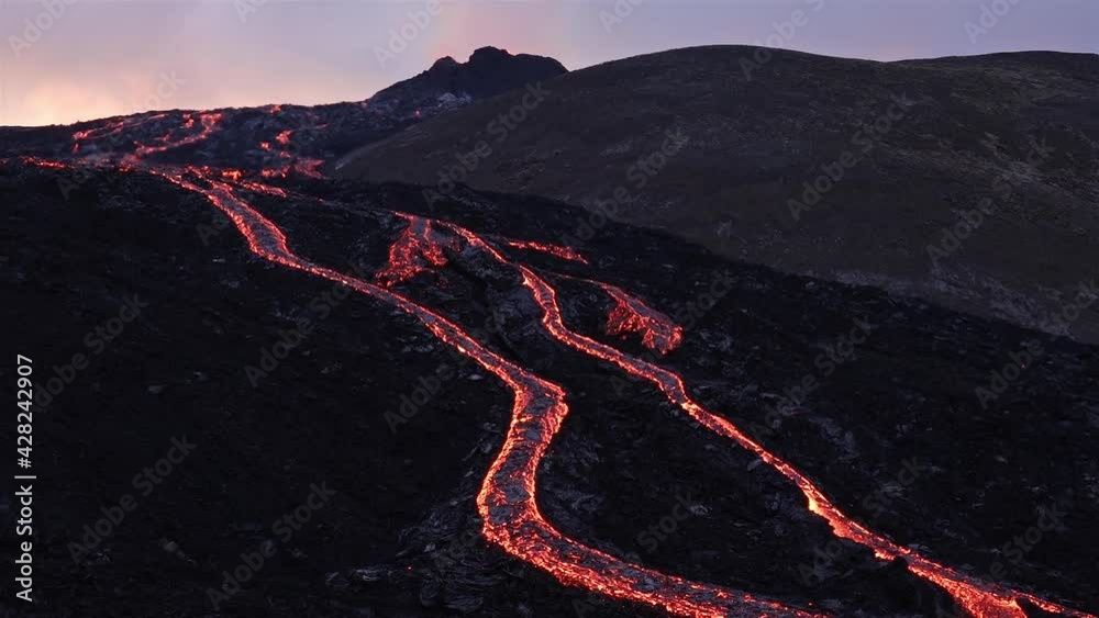 Winding rivers of lava from erupting volcano Iceland sunset glow 2021
