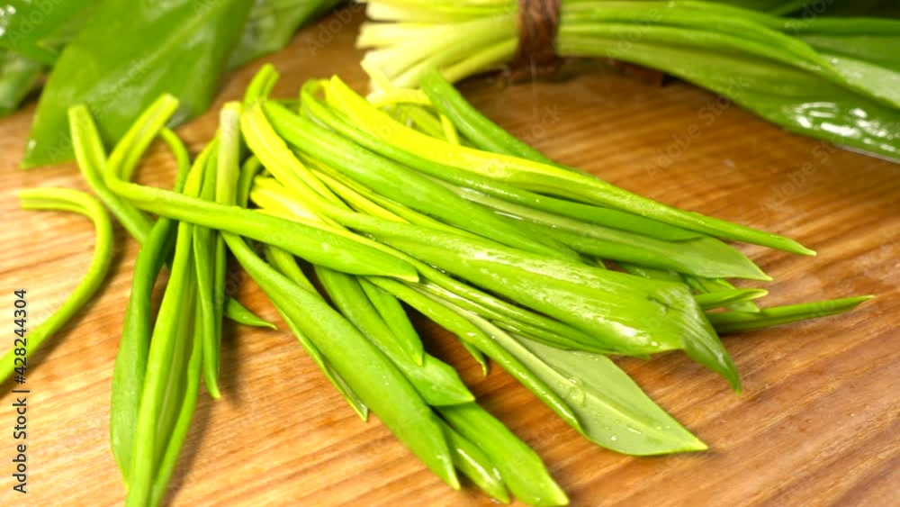 Wild garlic leaves on a wooden cutting board. Wild garlic leaves on a wooden cutting board.