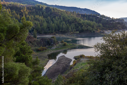 Beautiful landscape with mountains and lake. Turquoise water and beautiful autumn trees with yellow leaves and coniferous forests. Cyprus