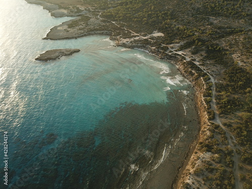 Beautiful Cyprus landscape top View from a drone.  Juniper forest, rocky shore and blue lagoon with clear water. Turquoise Mediterranean sea at dawn. The nature reserve of the Akamas Peninsula