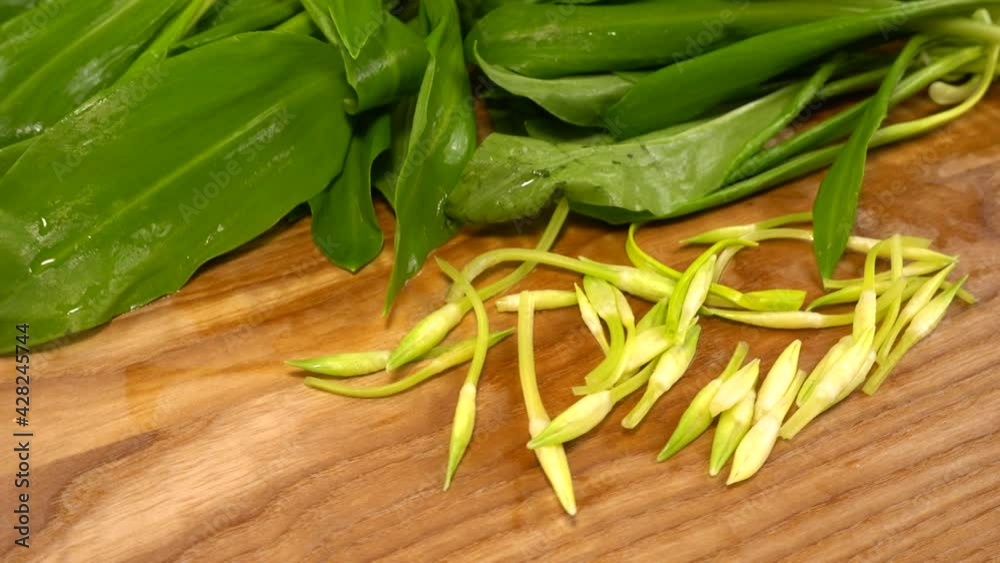 Wild garlic leaves on a wooden cutting board.