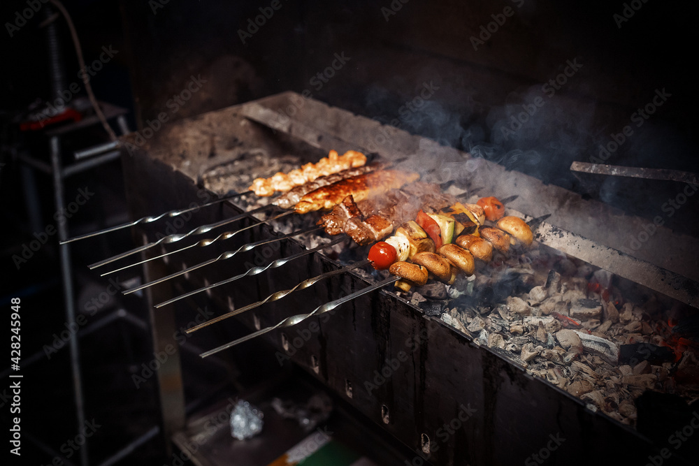 Shish kebab from meat, mushrooms and vegetables are fried on the grill Shish kebab from meat, mushrooms and vegetables are fried on the grill