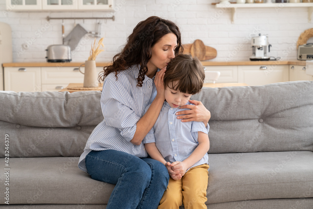 Mom calm frustrated preschool boy embracing and soothing. Young mother care for upset little son. Loving woman express love and support for child. Motherhood protection, sharing pain and family trust