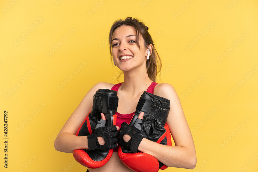 Young caucasian woman isolated on blue background with boxing gloves