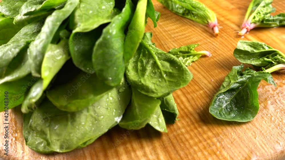 Spinach leaves on a wooden cutting board. Spinach leaves on a wooden cutting board.