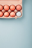 Golf ball in a box of eggs, flatlay on blue background
