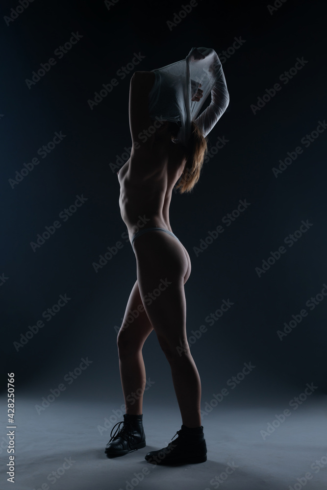 Naked beautiful woman posing on black background. Fine Art style. Naked beautiful woman posing on black background. Fine Art style.