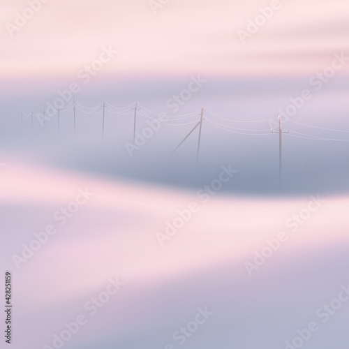 Power lines. Foggy clouds. Pastel fog waves. Countryside landscape