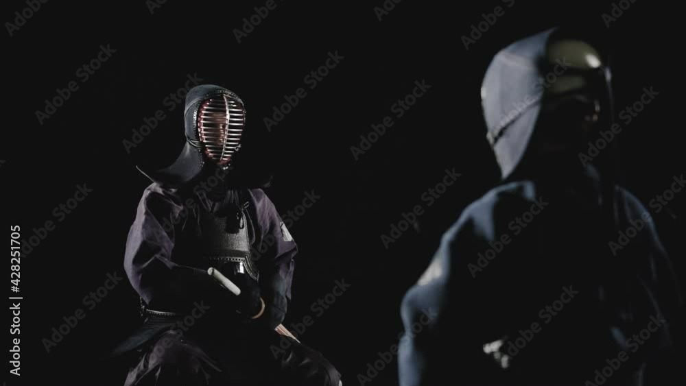 Japanese kendo fighters with bamboo swords on a black background. Slow motion Japanese kendo fighters with bamboo swords on a black background. Slow motion
