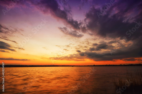 colorful sunset at the river bank © pobaralia