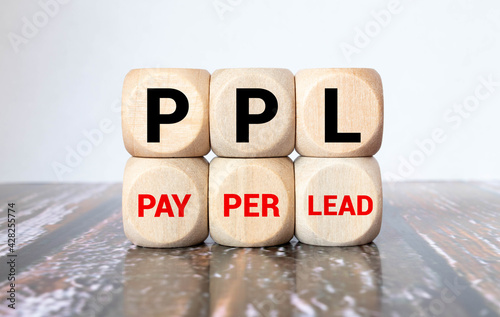 PPL - Pay per Lead - handwritten text in a notebook on a desk - on wooden block photo