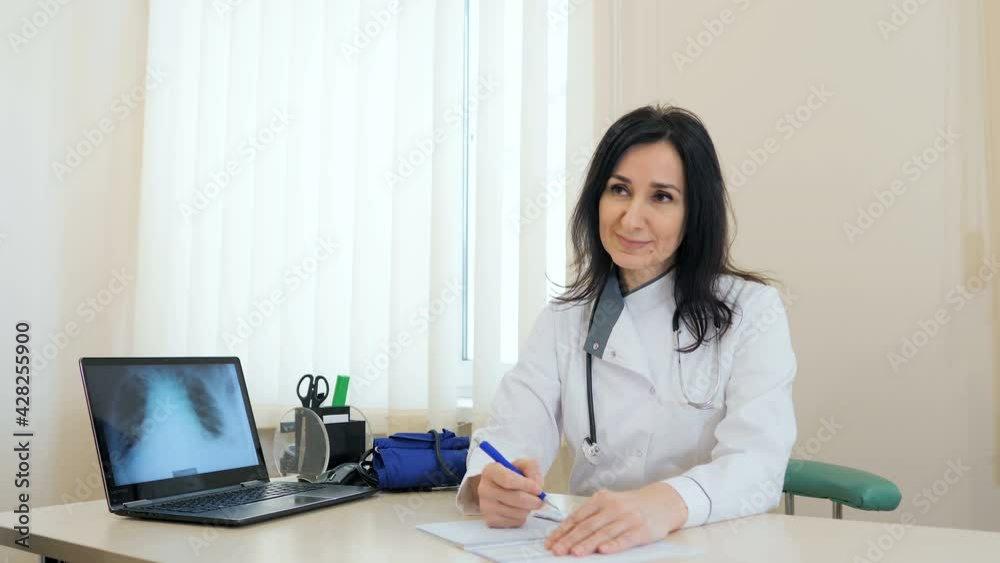 A general practitioner in a white coat advises an elderly married couple of pensioners at a control meeting at the clinic, health insurance, the concept of health care for the elderly. A general practitioner in a white coat advises an elderly married couple of pensioners at a control meeting at the clinic, health insurance, the concept of health care for the elderly.