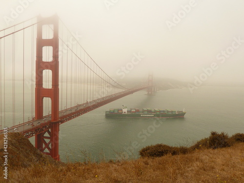 High viewpoint of Golden Gate Bridge in some fog with ship passing underneath