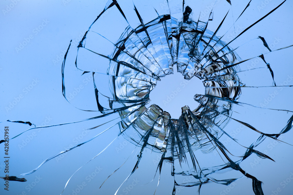 Obraz premium Cracks in the window glass on a background of sky.