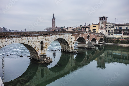 View of Stone Bridge (Ponte Pietra or Pons Marmoreus) - Roman arch bridge crossing the Adige River in Verona, Italy. The bridge completed in 100 BC, is the oldest bridge in Verona. © dbrnjhrj