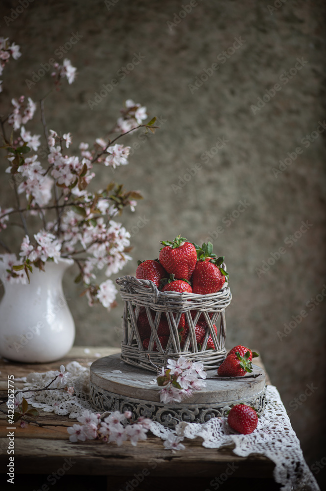 Strawberries in a small basket on the wooden table, vintage lifestyle. Strawberries in a small basket on the wooden table, vintage lifestyle.