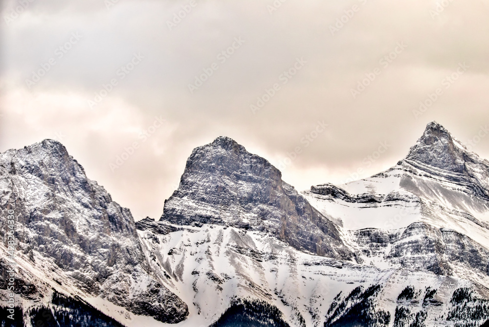 The snow topped Three Sisters and mountains surrounding Canmore Alberta at sunset