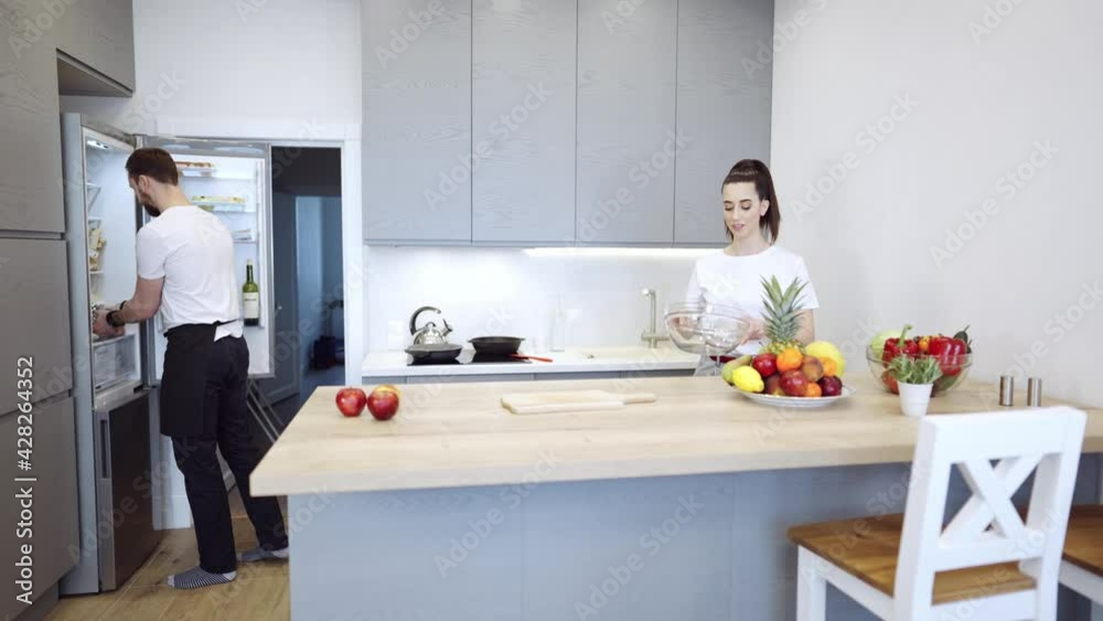 Couple Cooking Together At Home In The Kitchen Young cheerful couple cooking together at home in the kitchen. Healthy food diet and nutrition. Couple Cooking Together At Home In The Kitchen Young cheerful couple cooking together at home in the kitchen. Healthy food diet and nutrition.