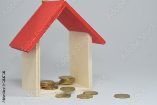 Selective Focus Of A Wooden House Miniature and Gold COins Isolated With White Background