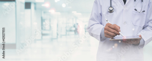 Healthcare and medical background, virtual hospital, telemedicine concept, doctor using digital tablet with blurred hospital interior as background