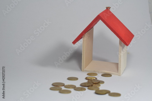 Selective Focus Of A Wooden House Miniature and Gold COins Isolated With White Background