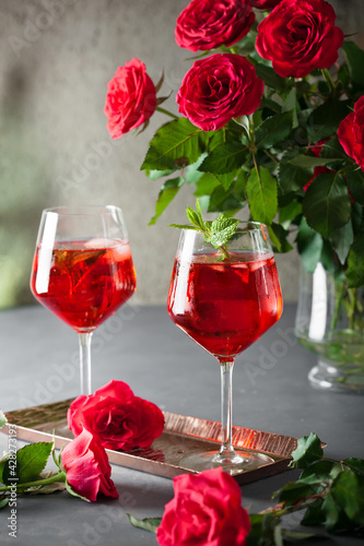 Two alcohol cocktails set with red roses