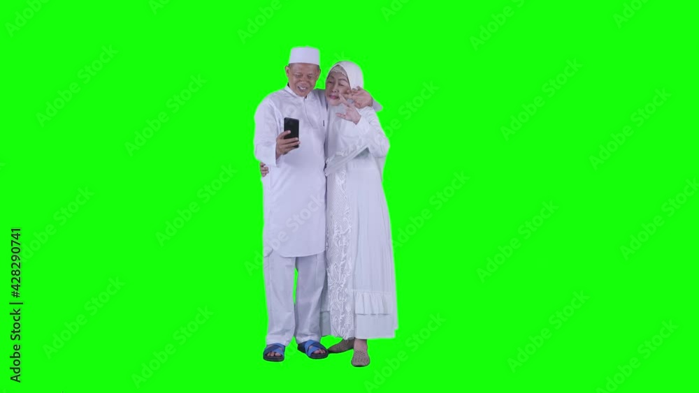 Muslim elderly couple doing video call on studio Muslim elderly couple doing video call on studio