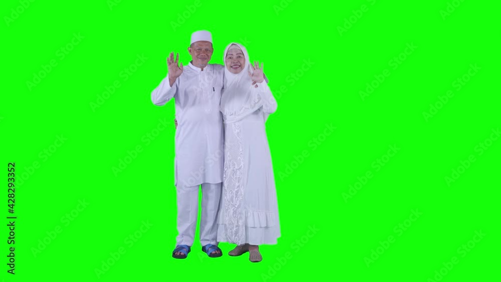Muslim old couple waving hands at the camera