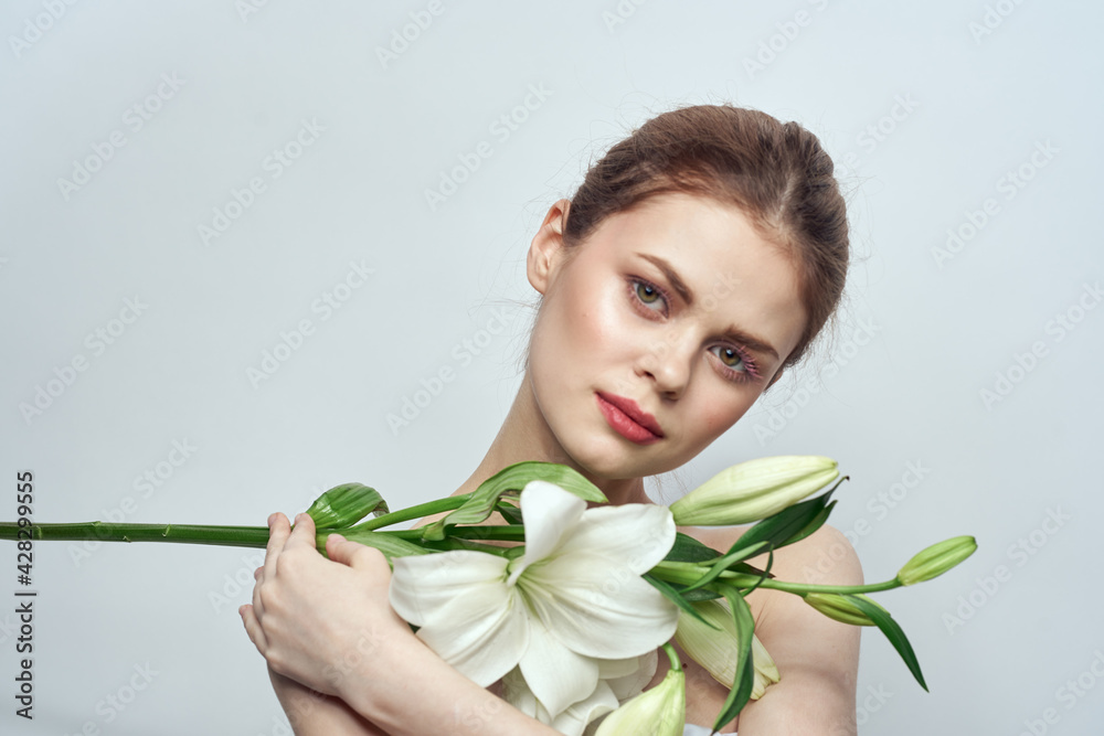 Lady with a bouquet of white flowers on a gray background portrait cropped view close-up Lady with a bouquet of white flowers on a gray background portrait cropped view close-up
