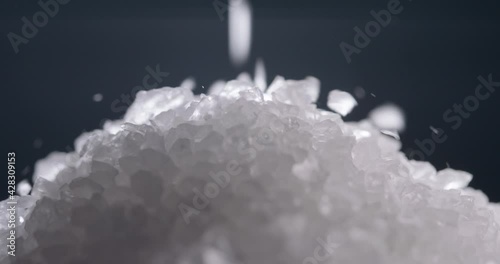 White salt granules falling into a pile. Bath cosmetic salt particles chaotically dropping - macro close up shot 4k footage photo