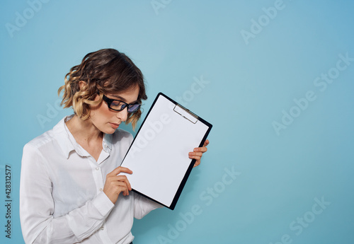 Business woman in a suit and glasses with a folder of documents in her hands and a white sheet of paper