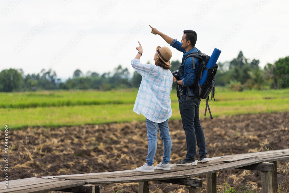A tourist woman enjoy taking photo of landscape during her summer vacation holiday in the greenery field. A stylish traveler woman in hat taking photo of herself and landscape while relaxing A tourist woman enjoy taking photo of landscape during her summer vacation holiday in the greenery field. A stylish traveler woman in hat taking photo of herself and landscape while relaxing