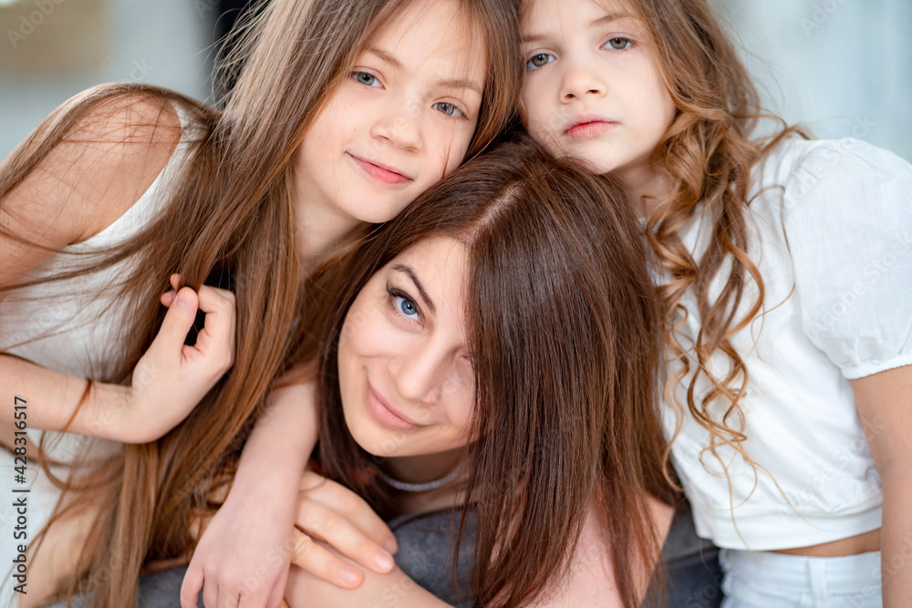 Mom cuddles with her daughters. happy family. unconditional love. Mom cuddles with her daughters. happy family. unconditional love.