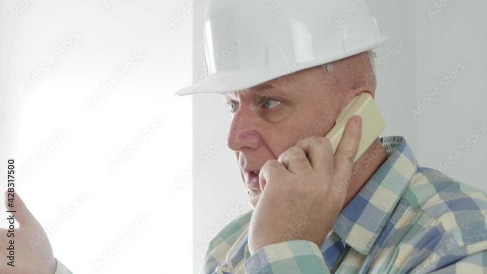Engineer in an Apartment Room Talking on the Telephone. Worker Heaving a Technical Discussion on Landline. Engineer in an Apartment Room Talking on the Telephone. Worker Heaving a Technical Discussion on Landline.