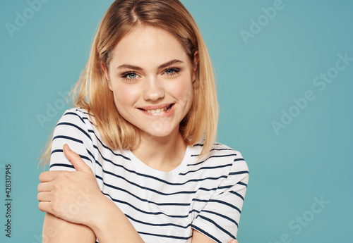 Happy blonde model striped t-shirt emotions blue background