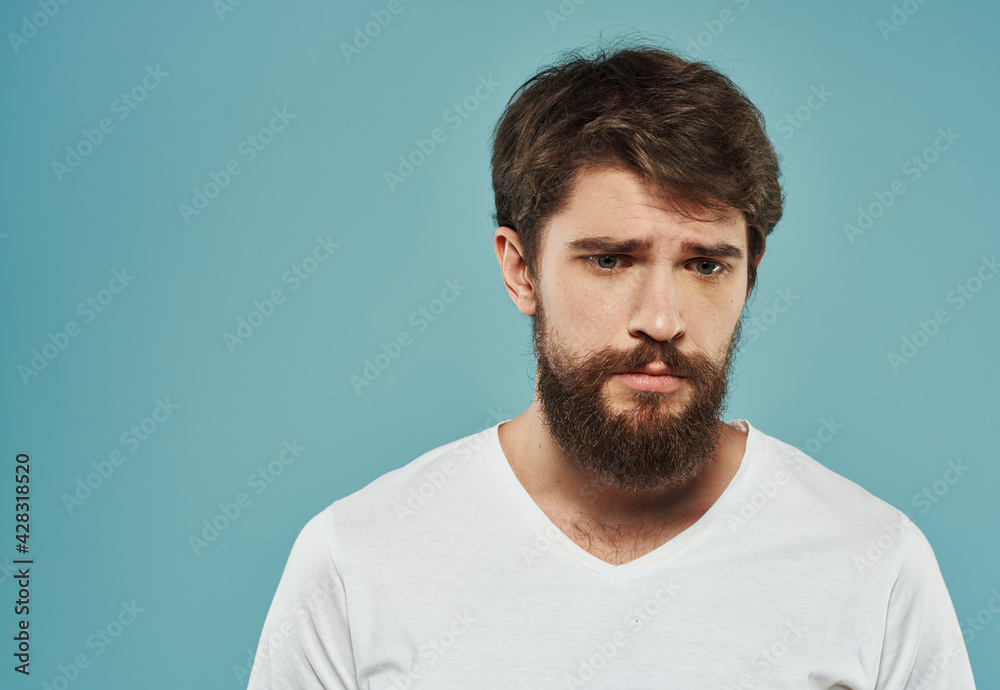 Portrait of a handsome man on a blue background with a cropped beard look Portrait of a handsome man on a blue background with a cropped beard look