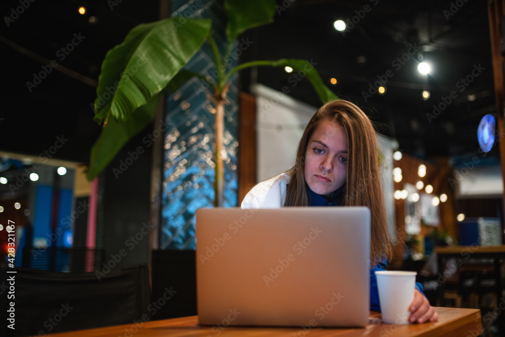 Young Woman Working On Laptop While Sitting In Cafe Young Woman Working On Laptop While Sitting In Cafe
