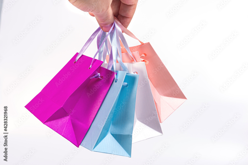 colorful shopping bags set in man hand isolated on white