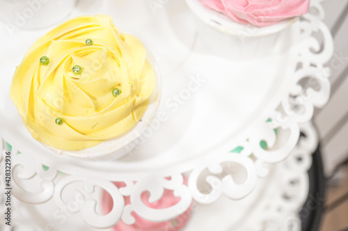 Sweet bright pastel color dessert cupcakes on muffin tower with pearl on top in a birthday or wedding party.