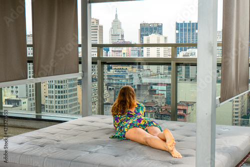 Young woman enjoying the view through the skyscrapers in São Paulo city center. Some of the most famous buildings and landmarks in the region and at the background, the Edifício Altino Arantes. photo