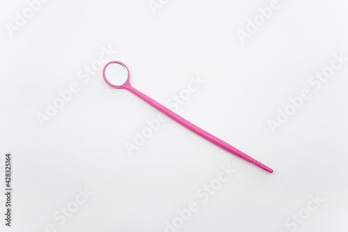 Mini pink eyelash extension mirror made of plastic on top of a white background.