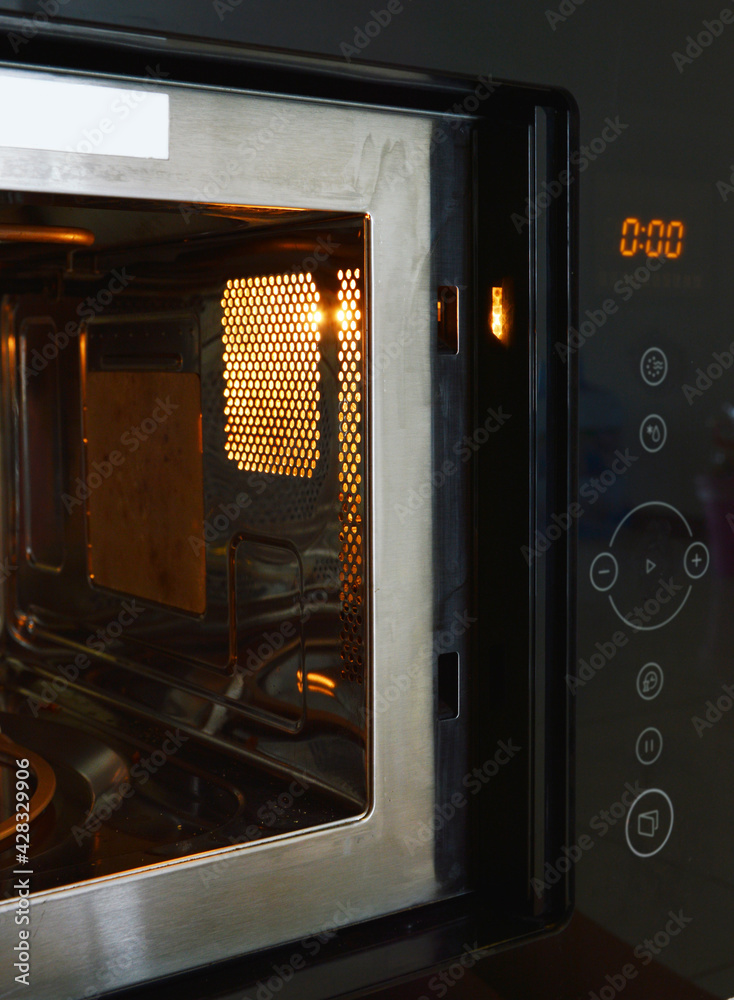 Fototapeta premium Microwave oven control panel and lighting inside