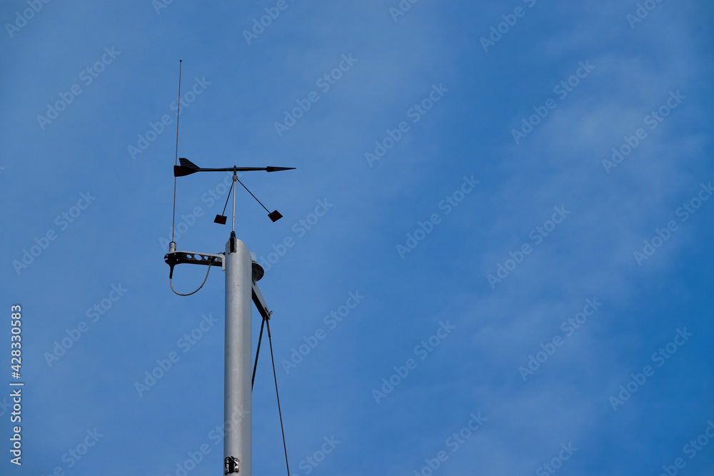 Wind direction meter. Radio system on steel column, blue sky. Wind direction meter. Radio system on steel column, blue sky.