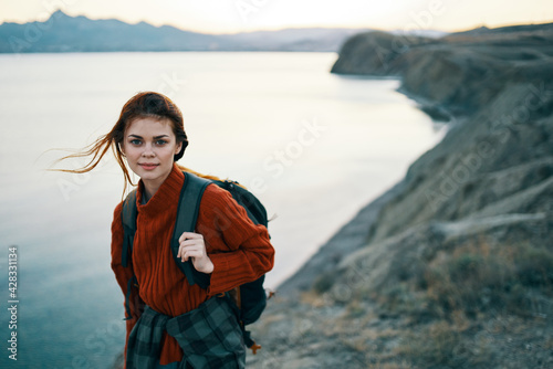 woman in a red sweater outdoors in the mountains fresh air sea mountains landscape