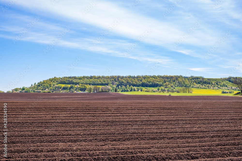 Plowed field at a table hill in a rural landscape at spring