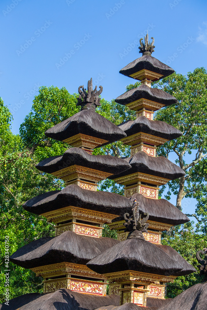The architecture of the Hindu temple on the island of Bali in Ubud, Indonesia, Asia. High thatched roof tower The architecture of the Hindu temple on the island of Bali in Ubud, Indonesia, Asia. High thatched roof tower