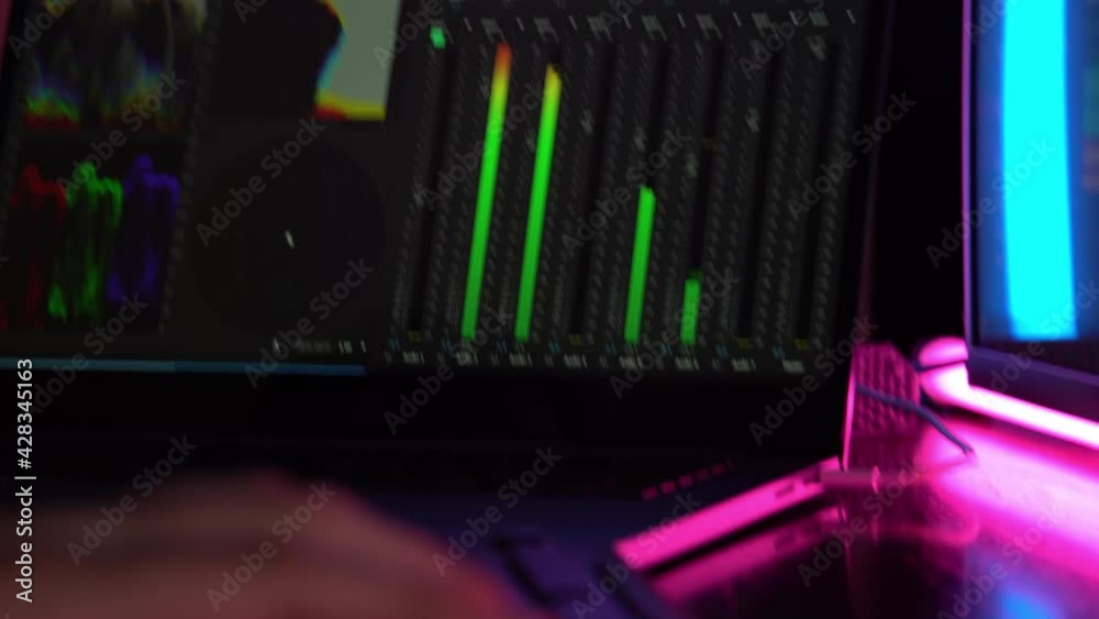 Video production. Video editing. Close-up of a hand on the keyboard.Color Correction. Sound editing. Film making. The work of a freelancer. Program for video editing. Neon light.