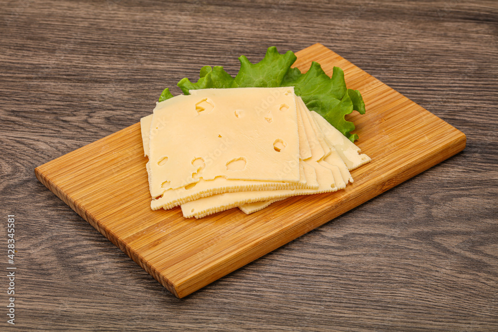 Sliced yellow cheese over board Sliced yellow cheese over board