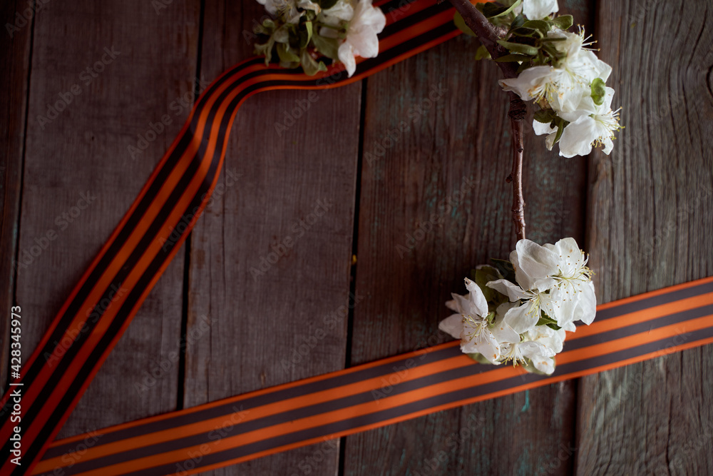 Apple tree branch with black orange ribbons. Wooden background Apple tree branch with black orange ribbons. Wooden background